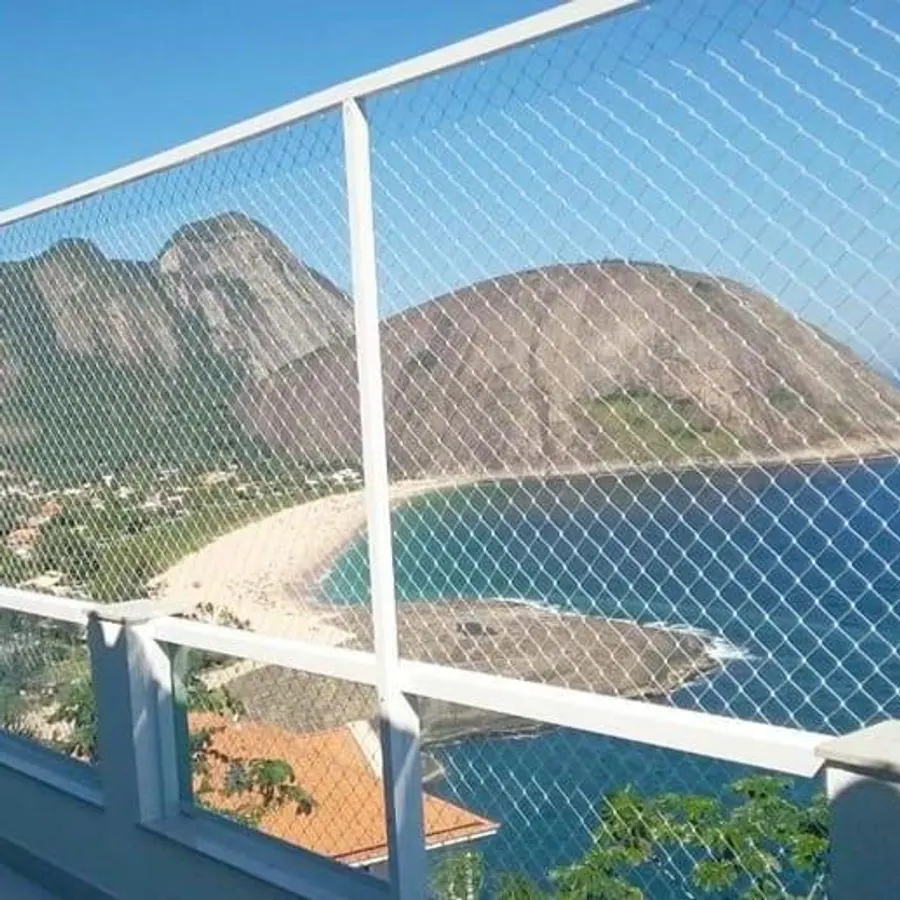 Varanda com rede de proteção branca e vista para o mar